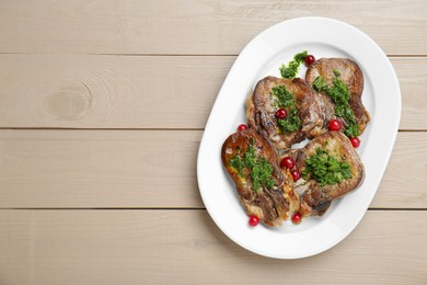 Photo of Tasty beef tongue pieces, salsa verde and berries on beige wooden table, top view. Space for text