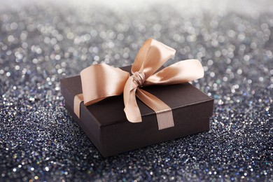 Image of Beautiful gift box on shiny silver glitters. Bokeh effect 
