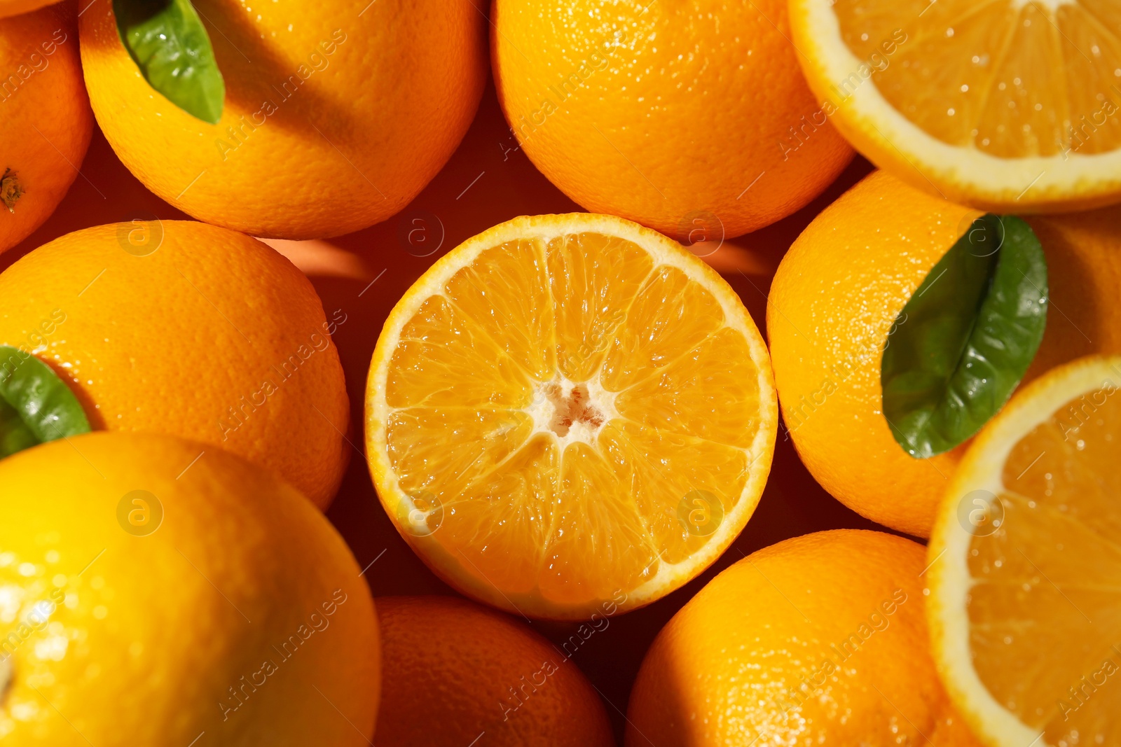 Photo of Tasty ripe fresh oranges and leaves as background, top view