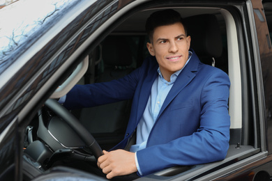 Photo of Handsome man driving his car, view from outside