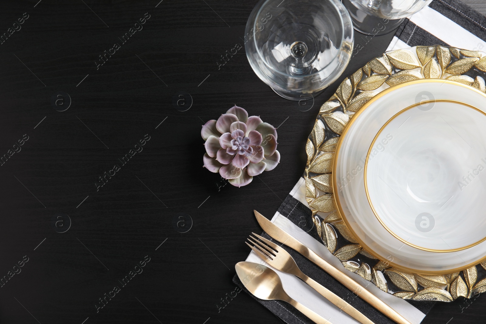 Photo of Elegant table setting and space for text on dark background, top view