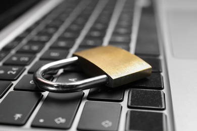 Photo of Cyber security. Metal padlock on laptop, closeup