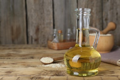 Fresh sesame oil and seeds on wooden table. Space for text