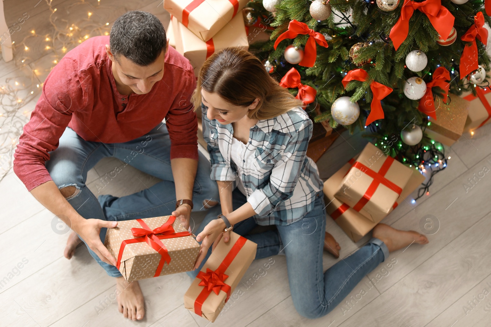 Photo of Young couple with Christmas gifts at home