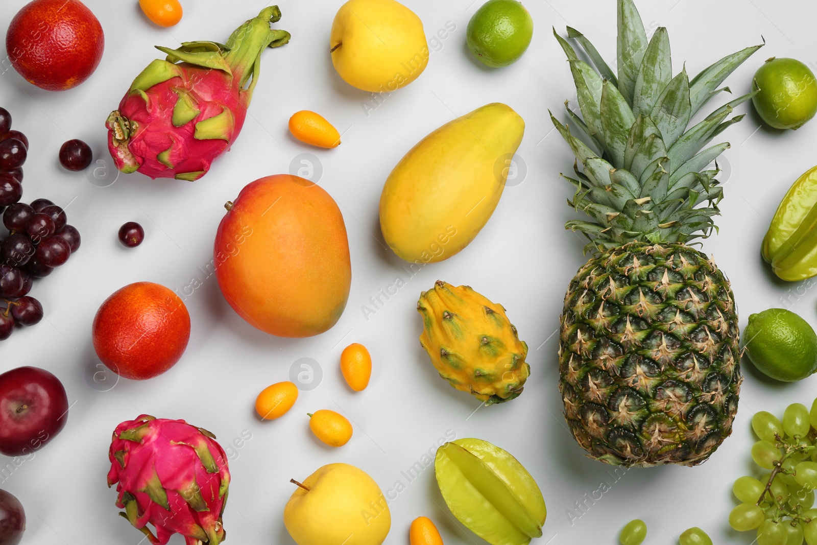 Photo of Many different delicious exotic fruits on light background, flat lay