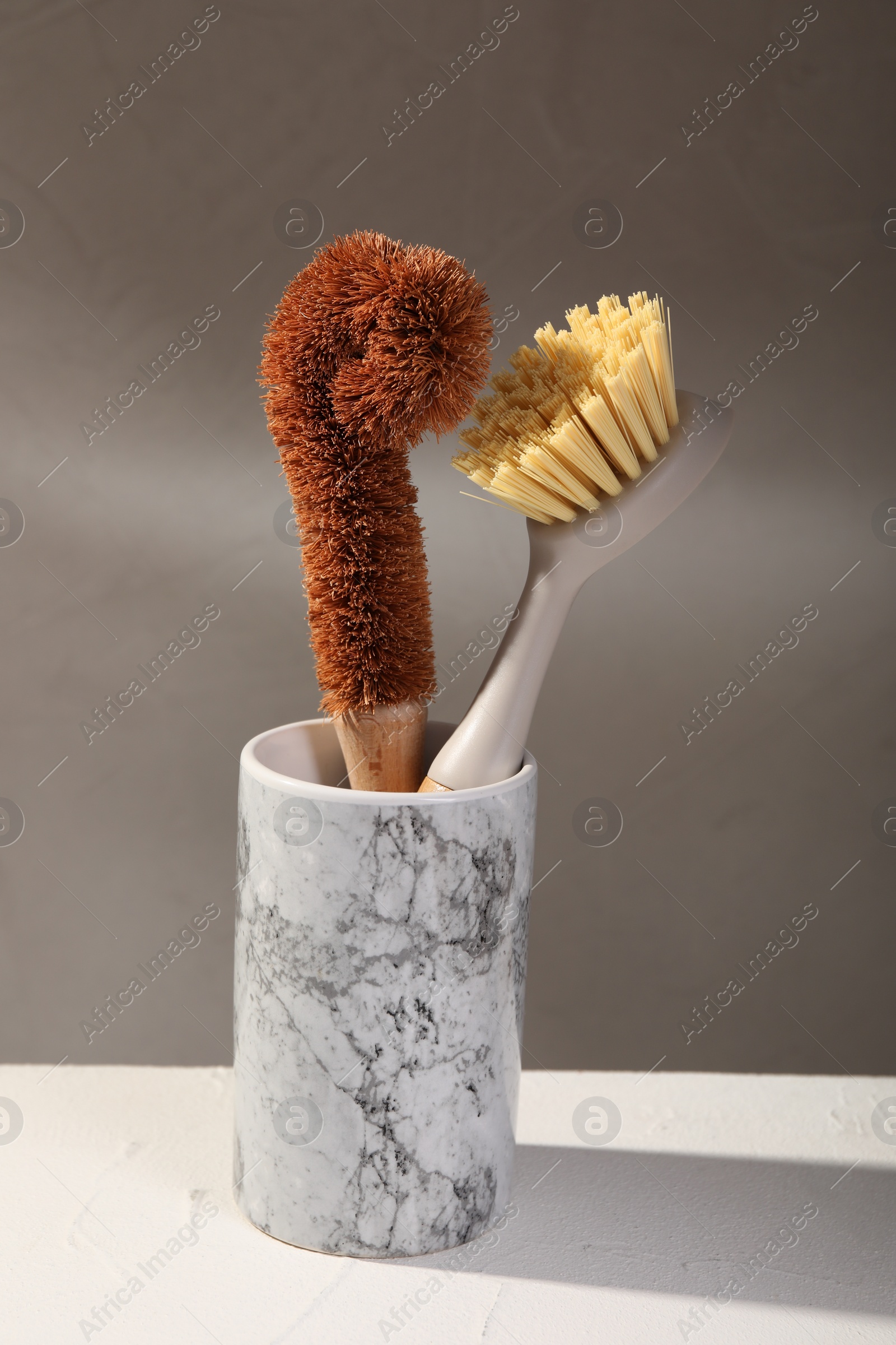 Photo of Cleaning brushes in holder on white table, closeup