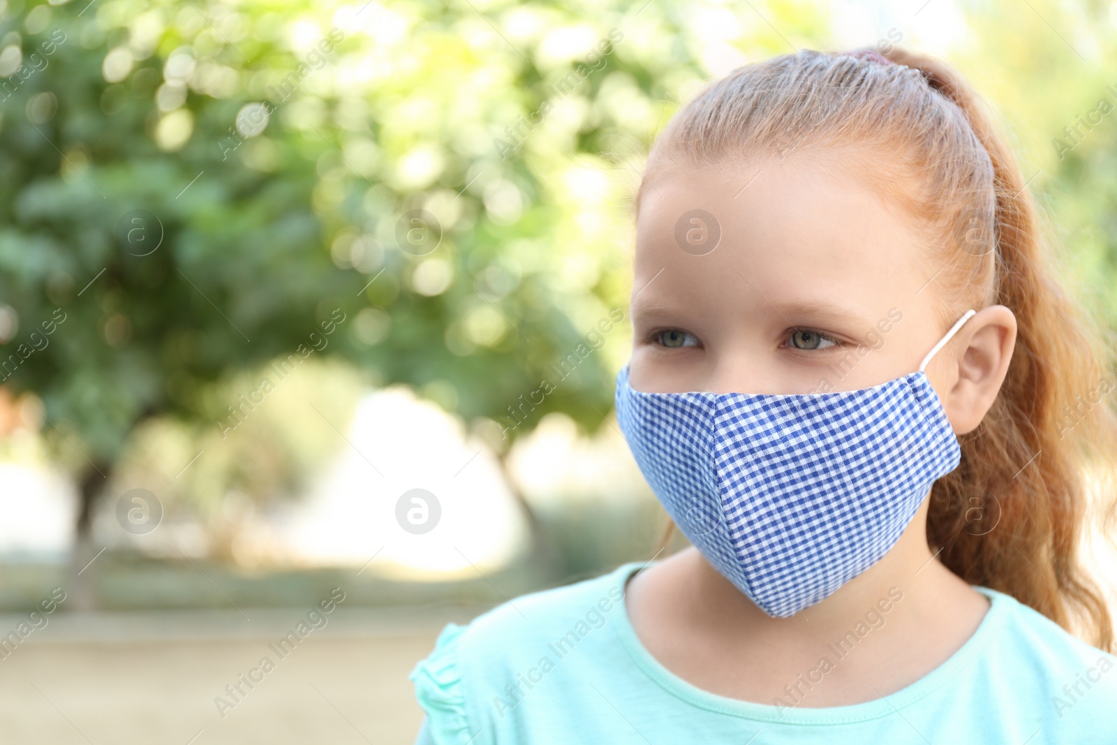 Photo of Preteen girl in protective face mask outdoors