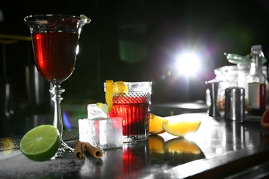 Photo of Fresh alcoholic cocktails in glasses on bar counter
