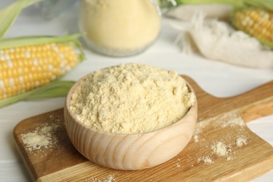 Photo of Corn flour in bowl on wooden board