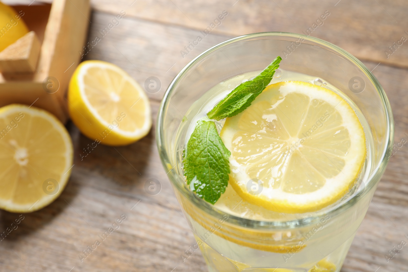 Photo of Glass of natural lemonade with mint on table, closeup