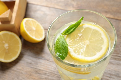 Photo of Glass of natural lemonade with mint on table, closeup