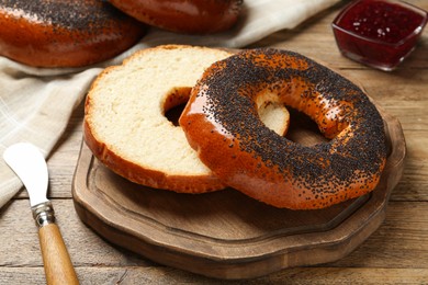 Delicious fresh bagels with poppy seeds on wooden table