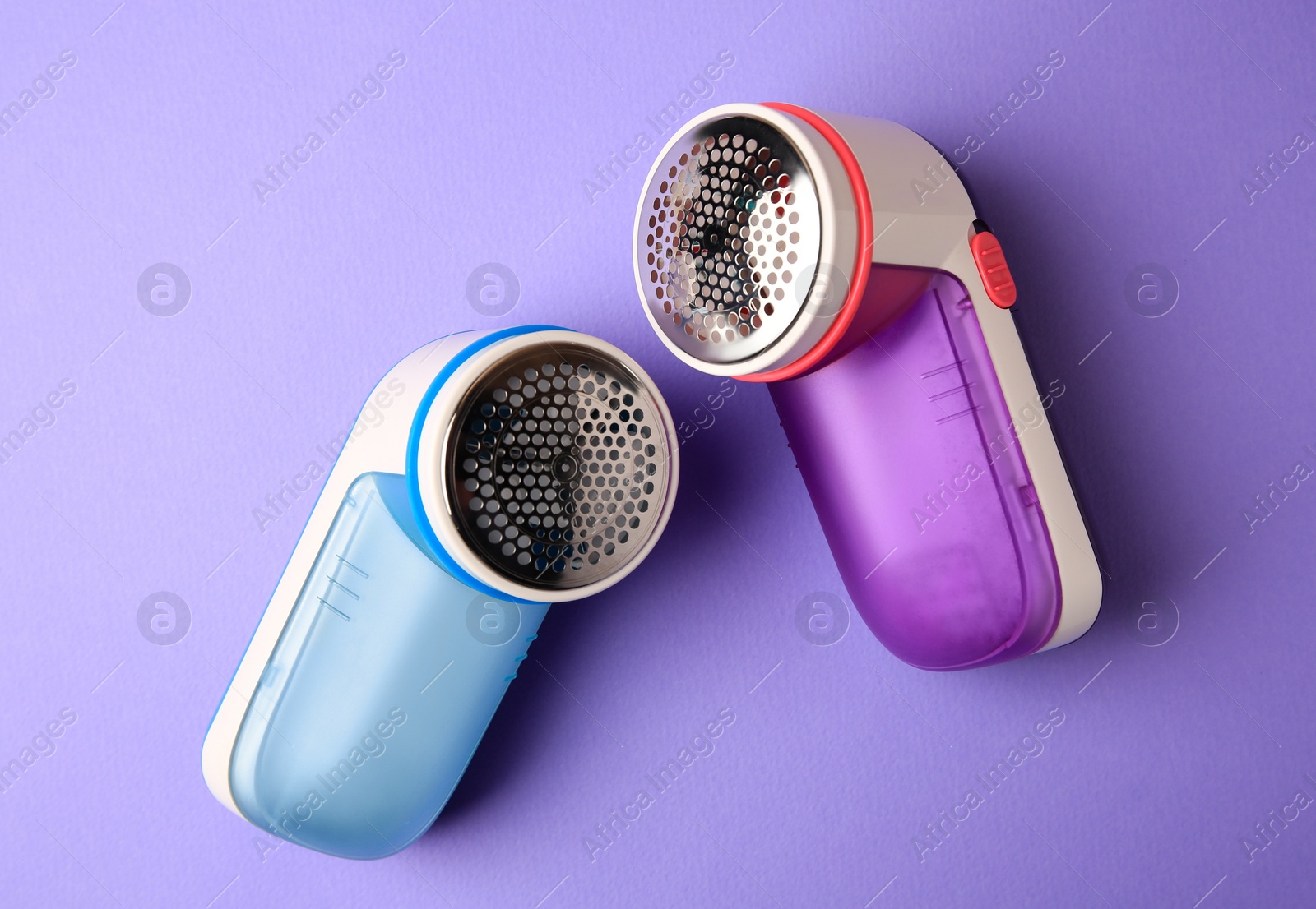 Photo of Modern fabric shaver on violet background, flat lay