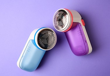 Modern fabric shaver on violet background, flat lay