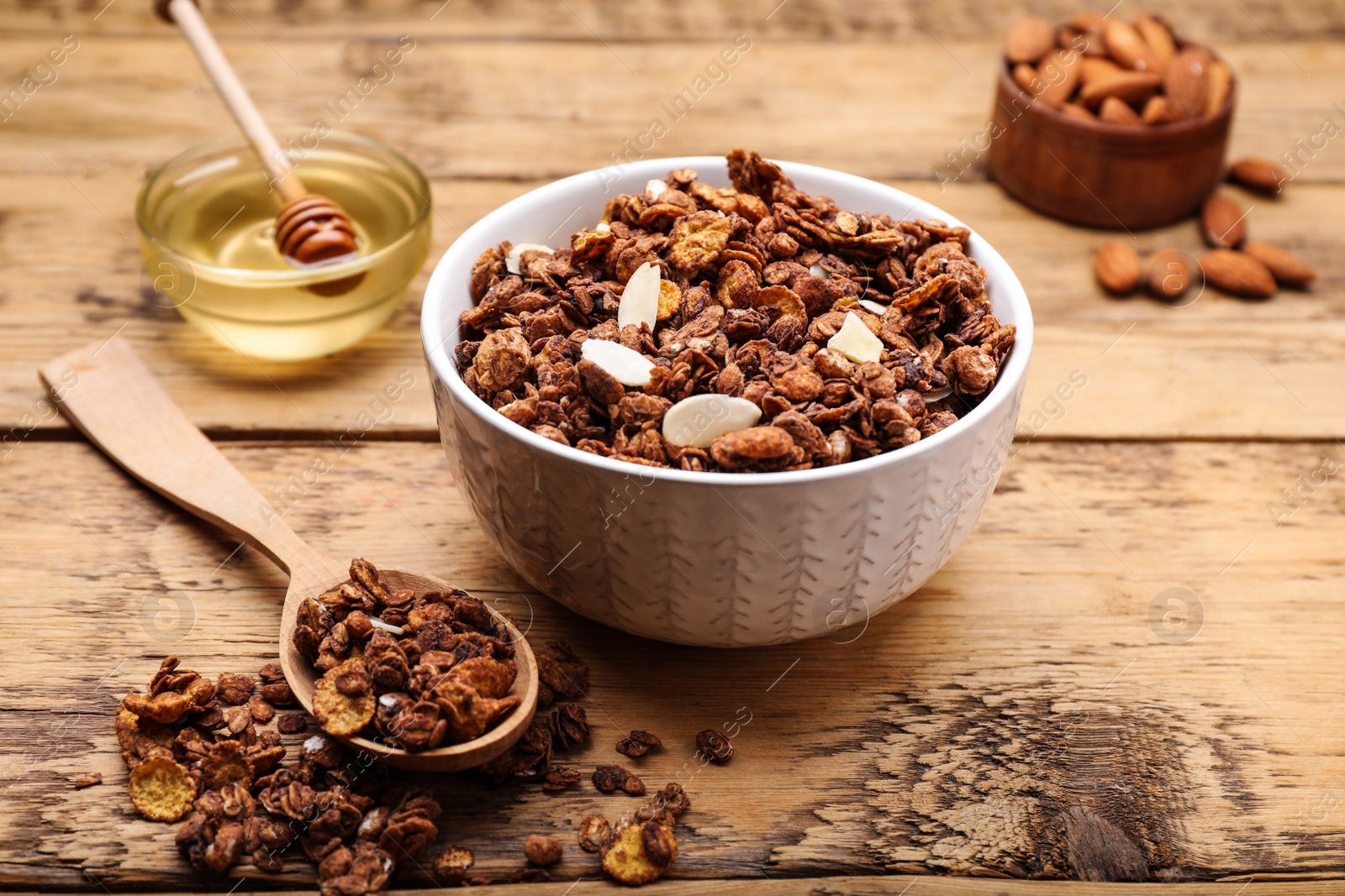 Photo of Tasty granola served with nuts and dry fruits on wooden table