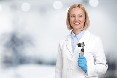 Professional dermatologist with dermatoscope on blurred background, space for text