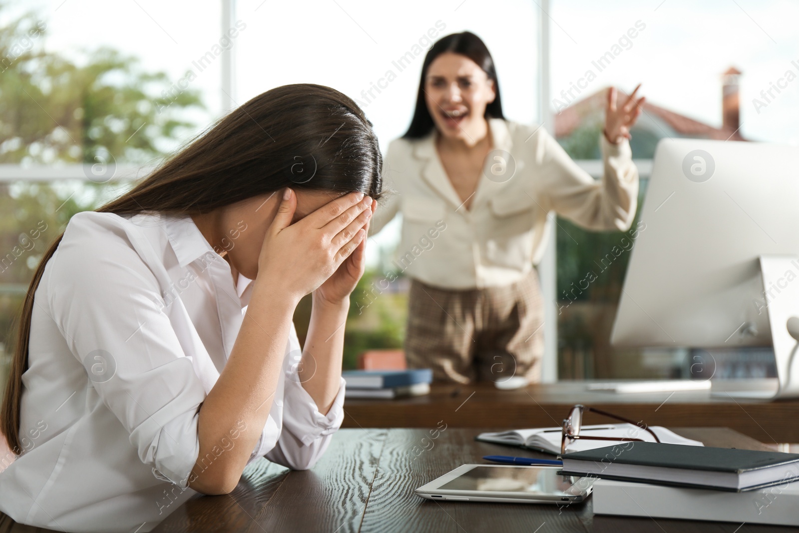 Photo of Boss screaming at employee in office. Toxic work environment