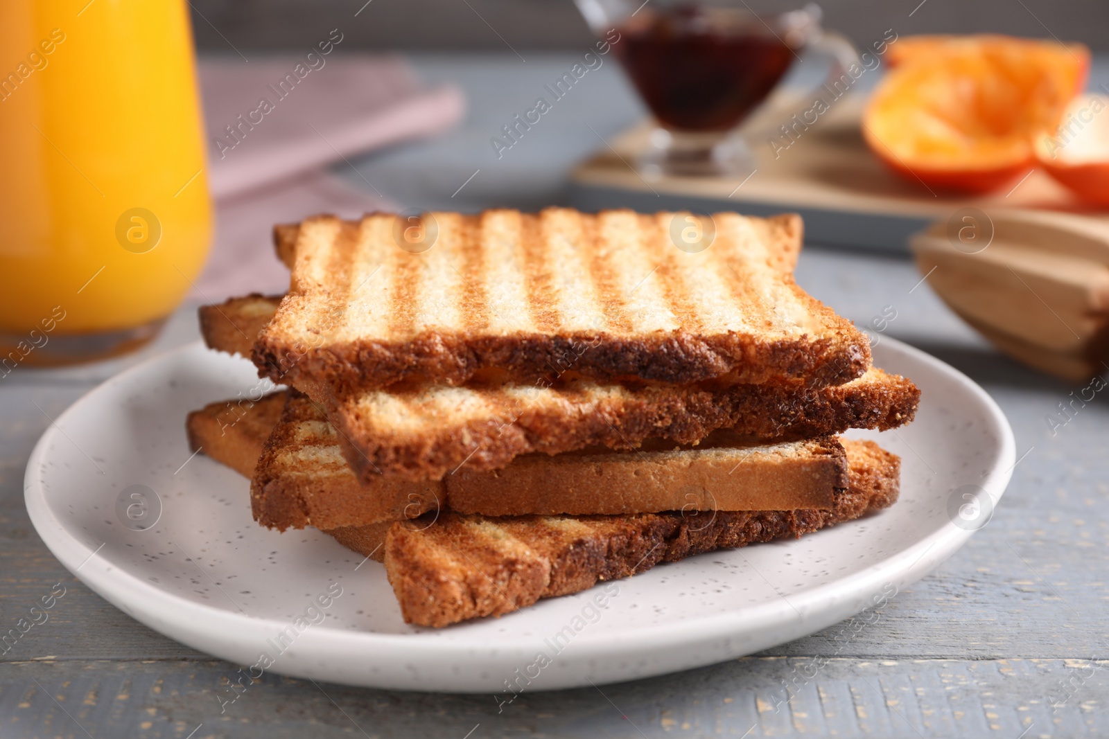 Photo of Tasty toasts served for breakfast on grey wooden table, closeup