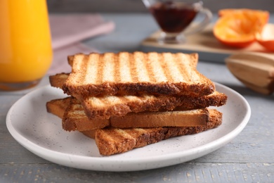 Photo of Tasty toasts served for breakfast on grey wooden table, closeup