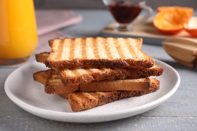 Tasty toasts served for breakfast on grey wooden table, closeup