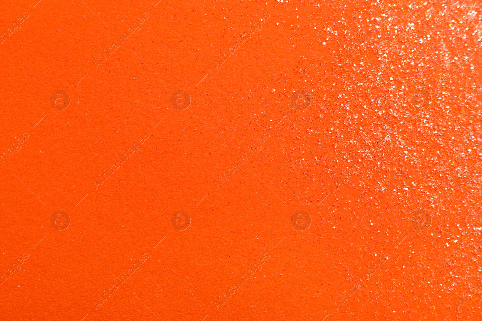 Photo of Shiny bright glitter on orange background, flat lay. Space for text