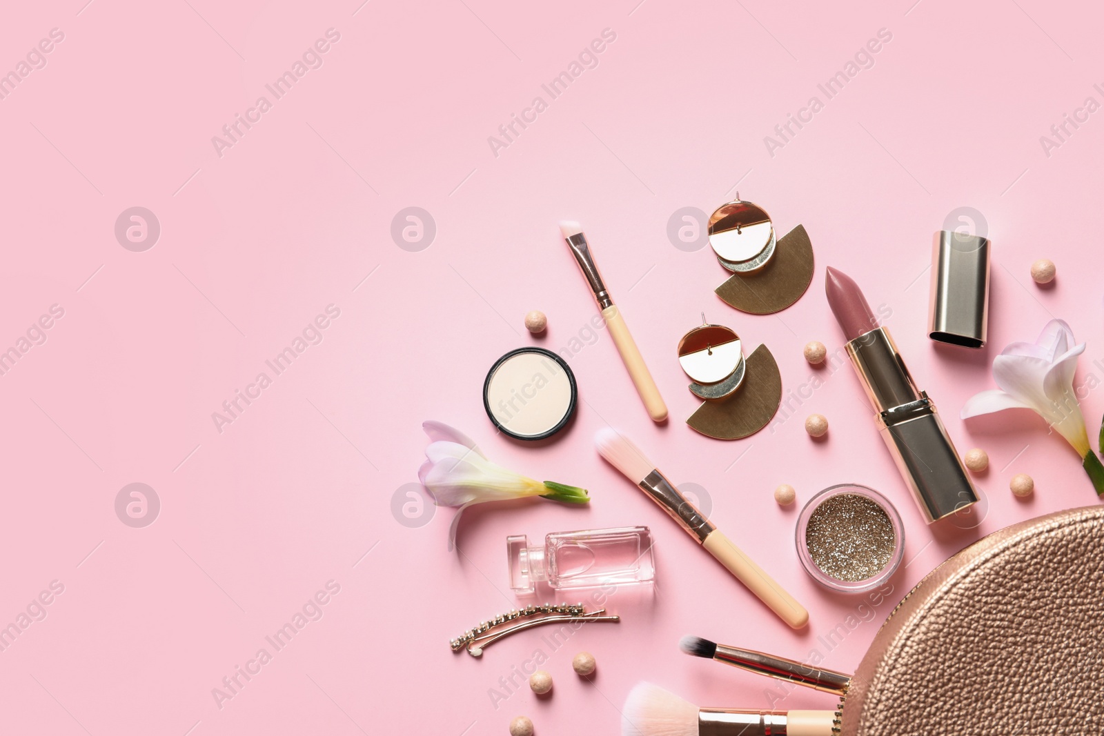 Photo of Makeup products, flowers and cosmetic bag on color background, flat lay with space for text