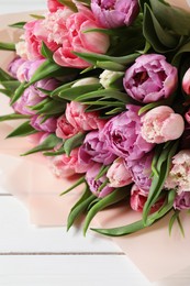 Photo of Bouquet of beautiful tulips on white wooden table, closeup