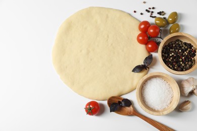 Fresh pizza dough and products on white background, flat lay. Space for text