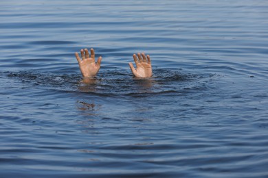 Photo of Drowning man reaching for help in sea, closeup