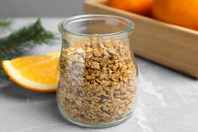 Photo of Jar of dried orange zest seasoning and fresh fruits on light grey table