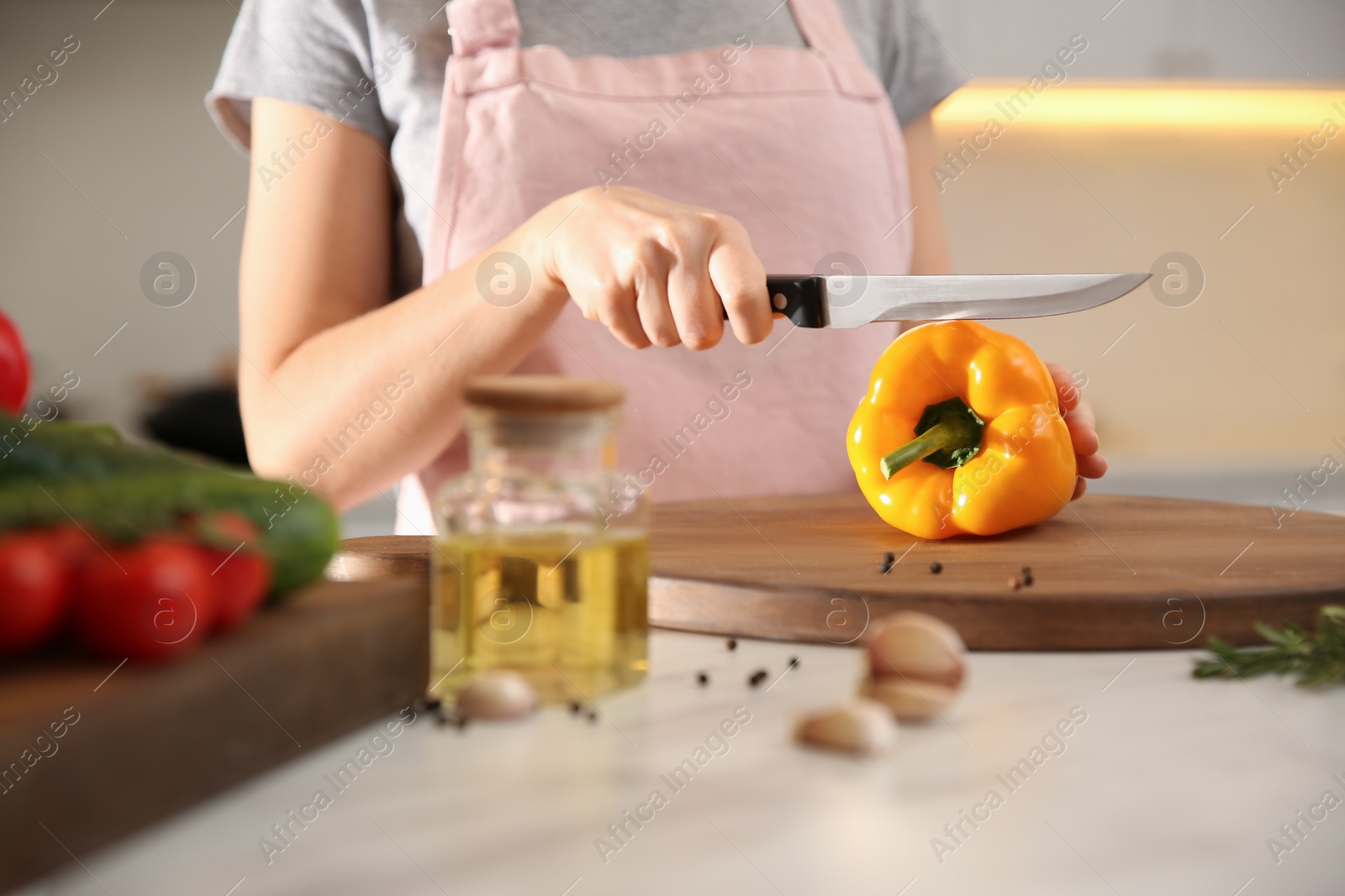 Photo of Young woman cooking at table in kitchen, closeup