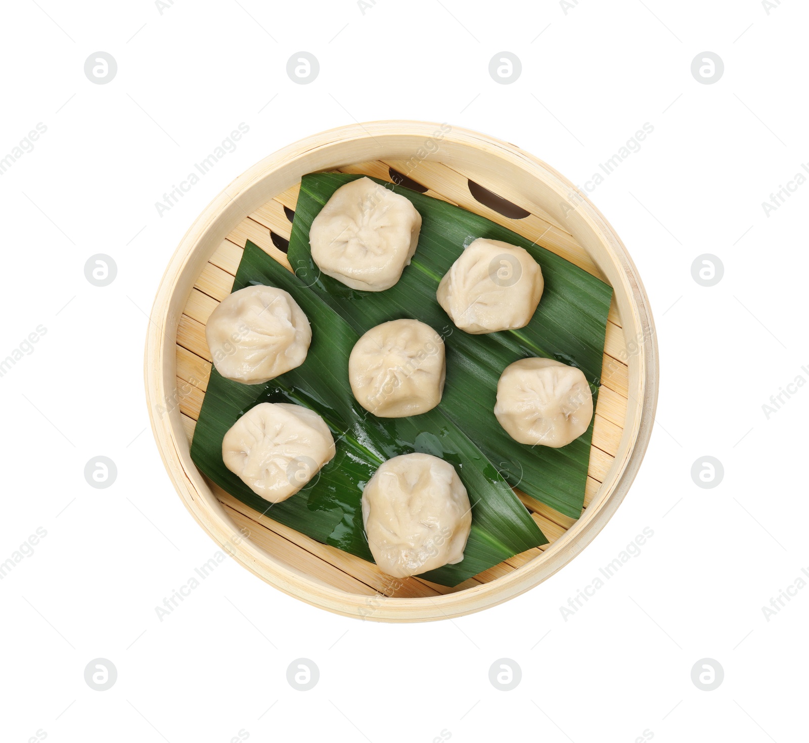 Photo of Bamboo steamer with leaves and tasty baozi dumplings on white background, top view