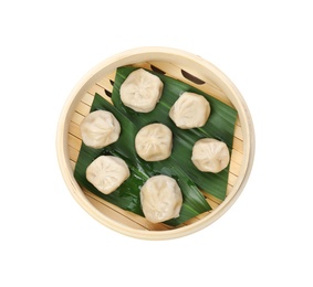 Photo of Bamboo steamer with leaves and tasty baozi dumplings on white background, top view