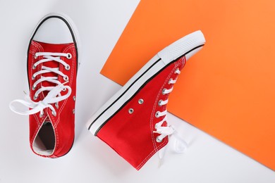 Pair of trendy sneakers on color background, flat lay