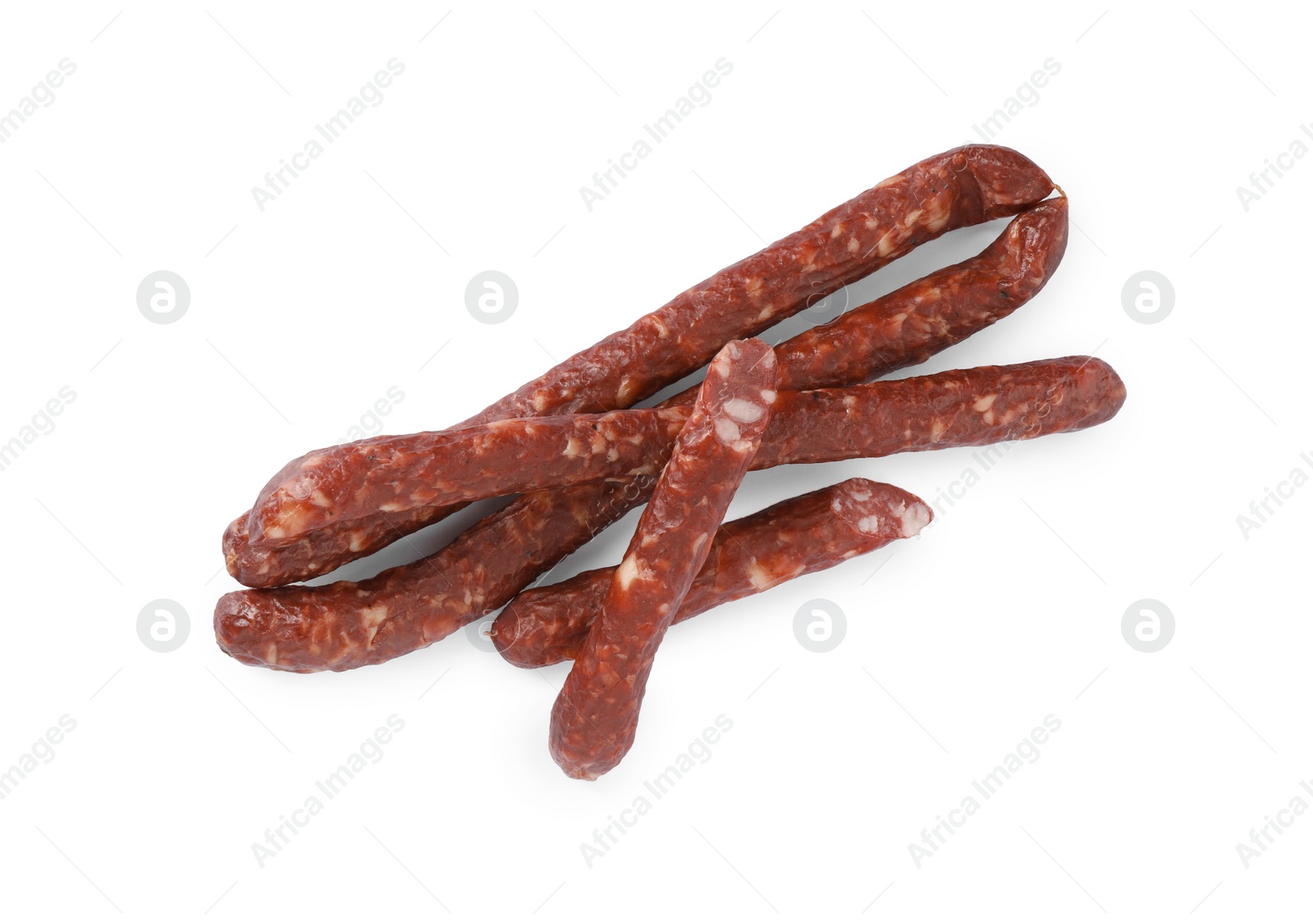 Photo of Thin dry smoked sausages isolated on white, top view