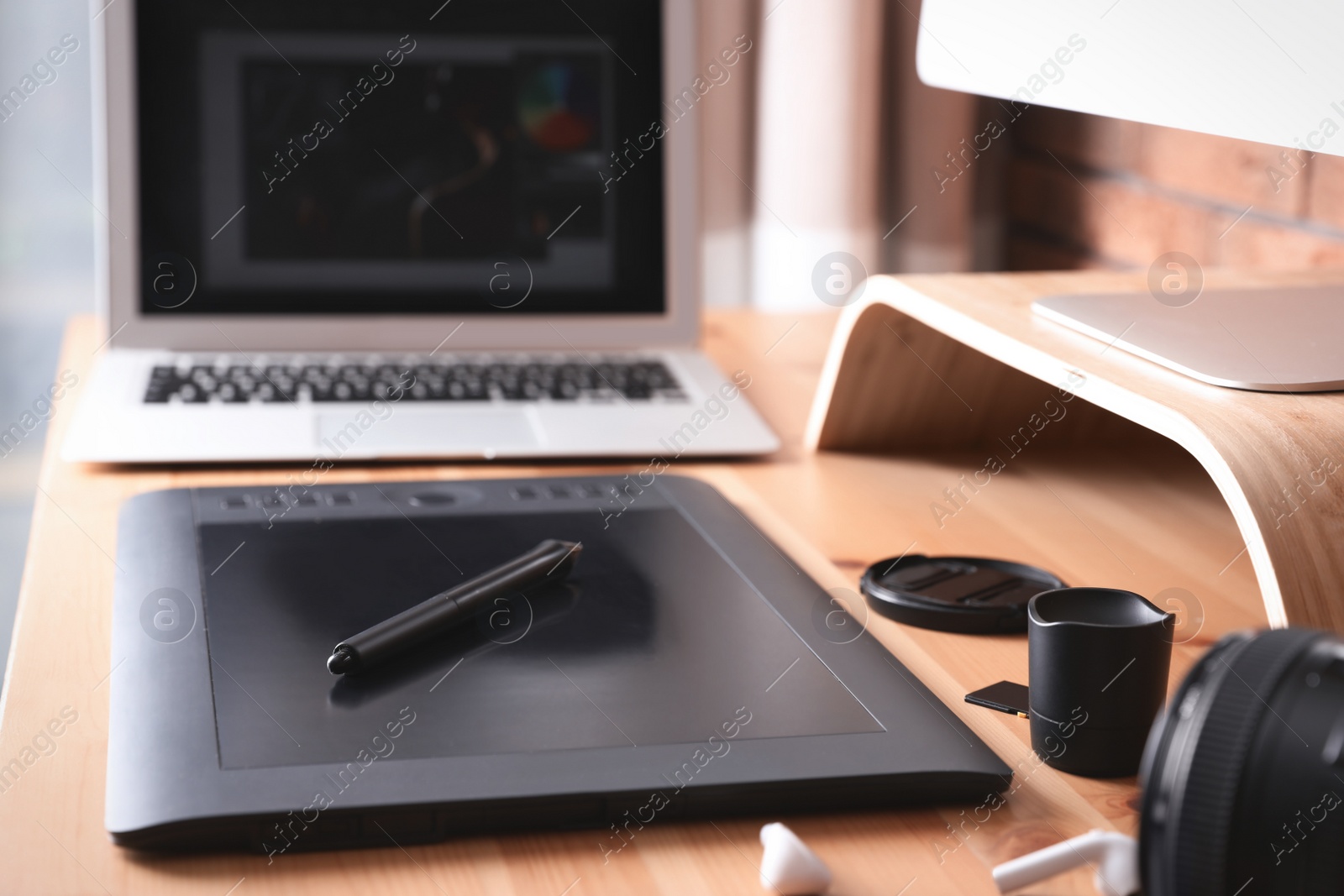 Photo of Modern retoucher's workplace with different digital devices on wooden table