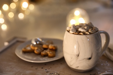 Cup of tasty hot drink and cookies on wooden table, closeup with space for text. Christmas atmosphere