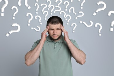 Image of Amnesia. Confused man and question marks on light grey background
