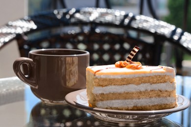 Photo of Tasty dessert and cup of fresh aromatic coffee on glass table outdoors, closeup