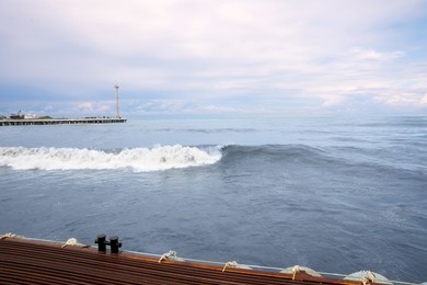 Photo of Beautiful sea with waves on cloudy day, view from pier