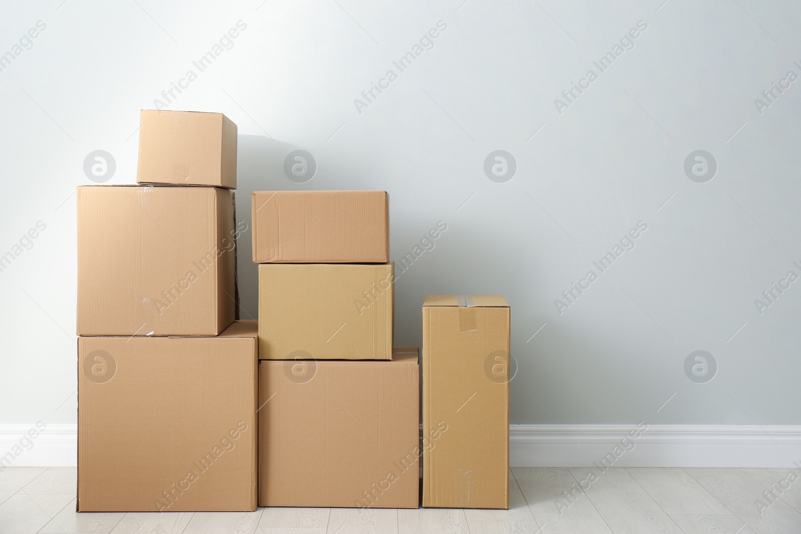 Photo of Cardboard boxes with stuff indoors, space for text. Moving day