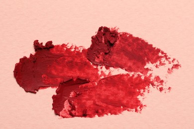 Photo of Smears of red lipstick on light background, top view