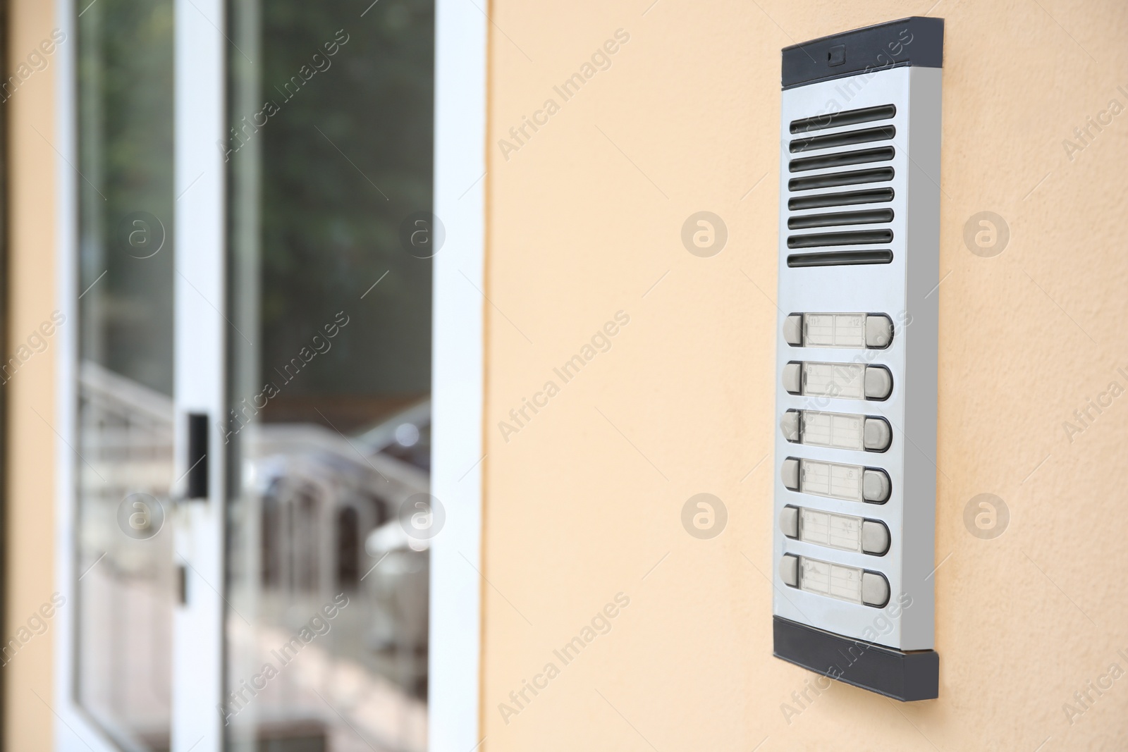 Photo of Modern intercom on beige wall, space for text. Security system