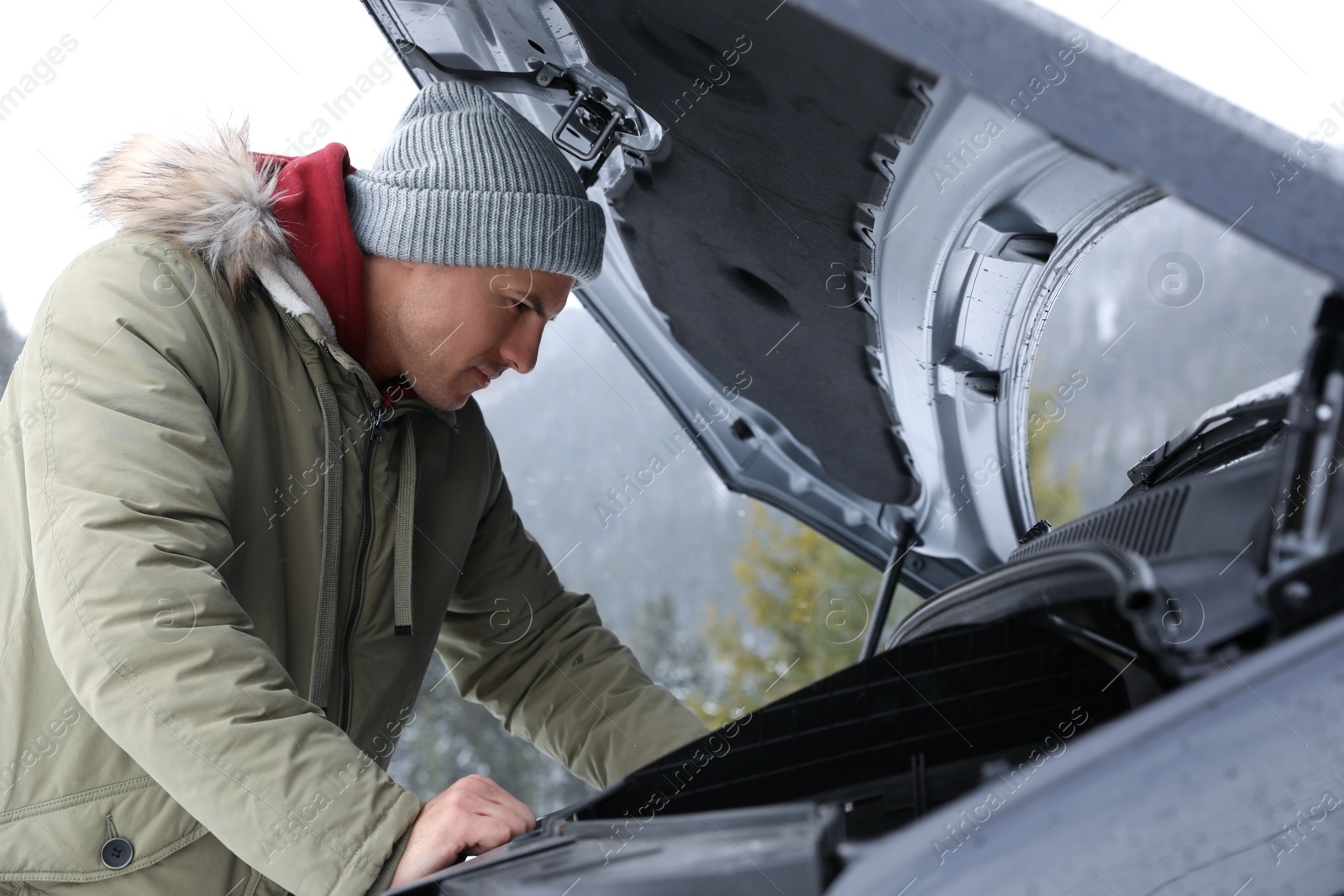 Photo of Stressed man near broken car outdoors on winter day