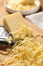 Photo of Grated and whole pieces of cheese on table, closeup