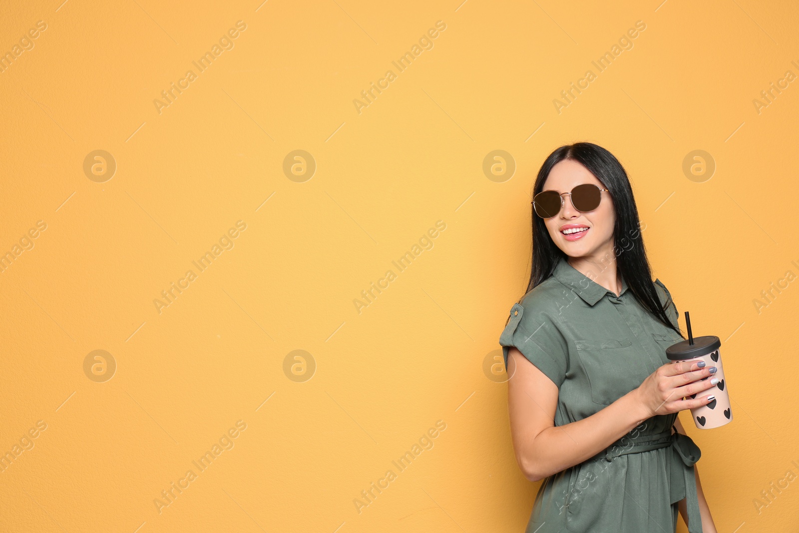 Photo of Beautiful woman in sunglasses posing on color background. Space for text