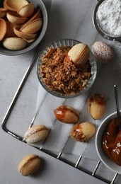 Photo of Delicious walnut shaped cookies with condensed milk on grey table, flat lay