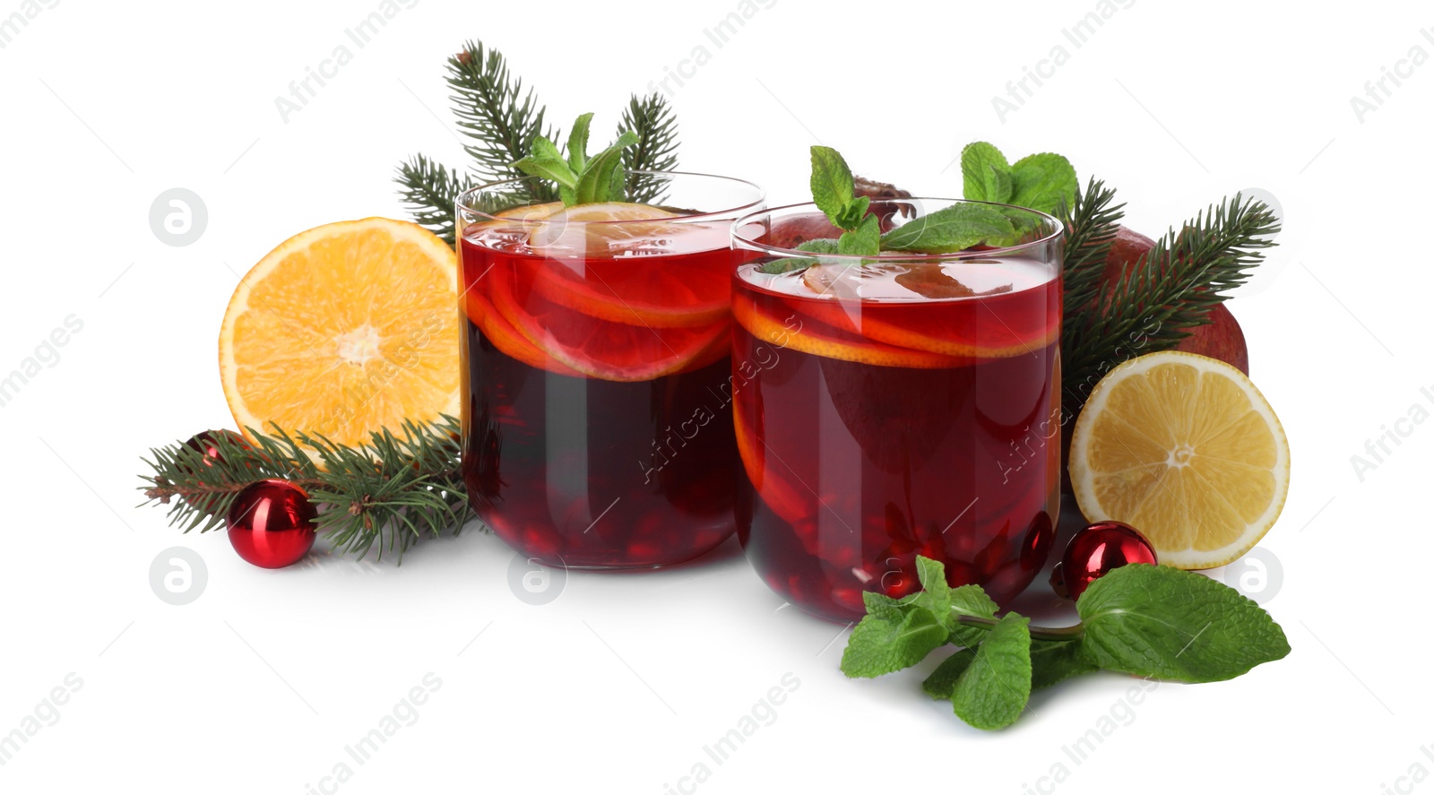 Photo of Christmas Sangria drink in glasses, fir branches, fruits and baubles on white background