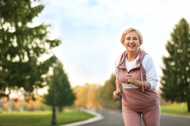 Photo of Mature woman jogging in park. Active lifestyle