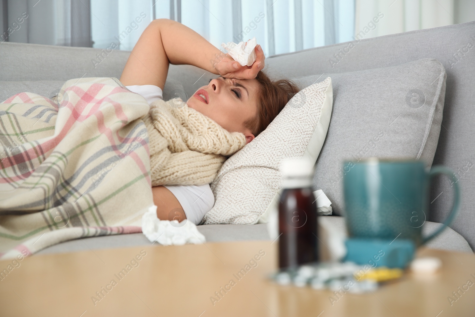 Photo of Sick woman lying on sofa at home. Influenza virus